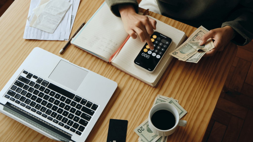 person organising money desk with laptop